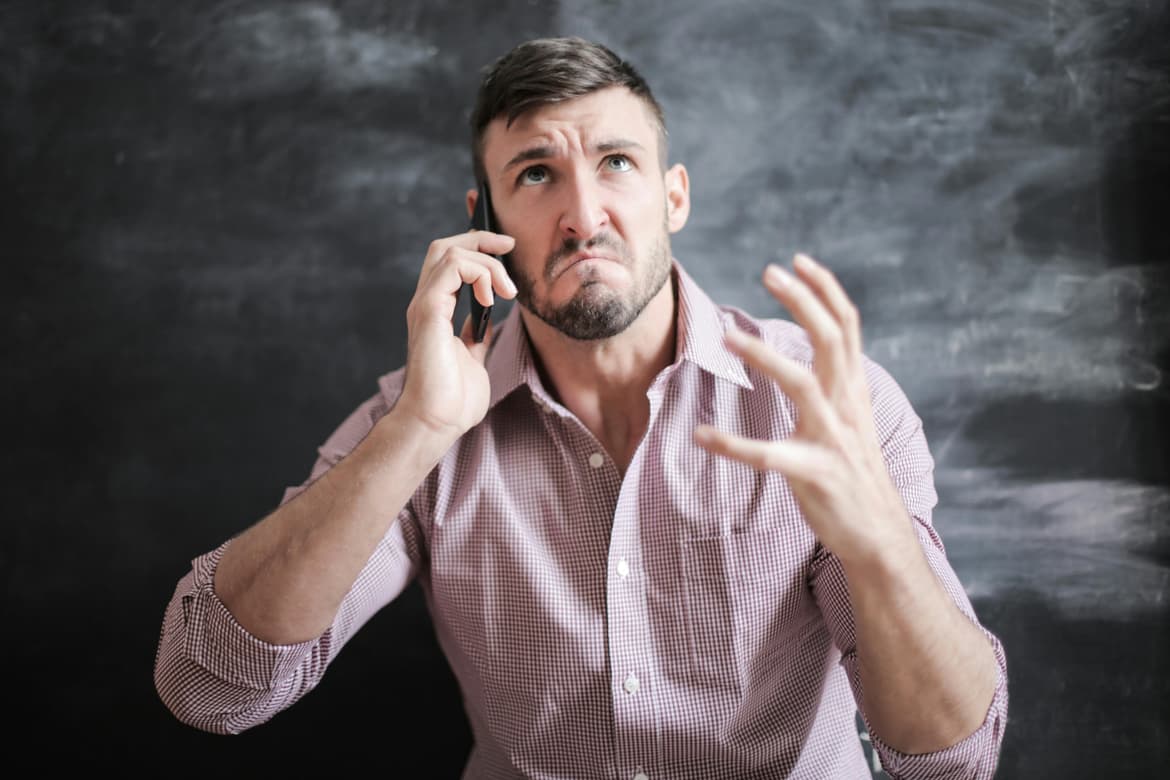 Man on phone looking agitated